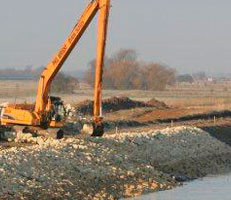 Excavator digging boundary wall