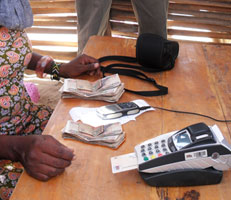 Table top containing cash and an EFT machine connected to a cell phone