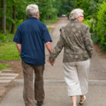 Two pensioners walking hand in hand