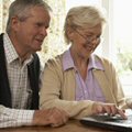two pensioners working at a compiuter screen