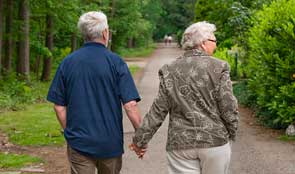 Elderly couple walking holding hands