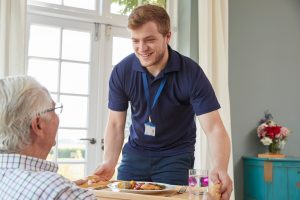 Carer with a meal for a patient