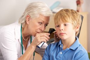 Doctor examining a young patients ear