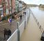 Street with flood defences next to a flooded river