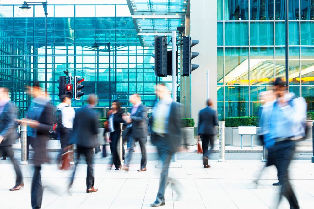 Blurred business people outside a large office