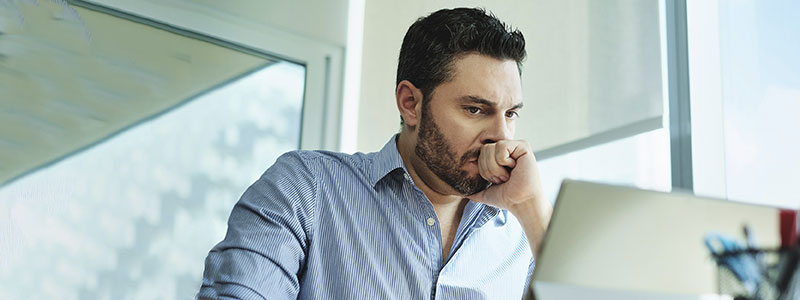 Man with laptop looking worried