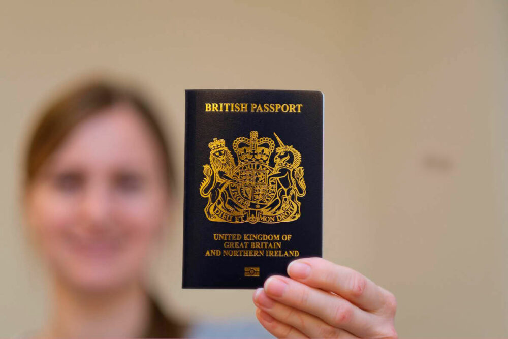Out of focus woman holding up a UK passport