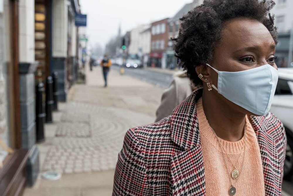 Woman walking down the street wearing a facemask