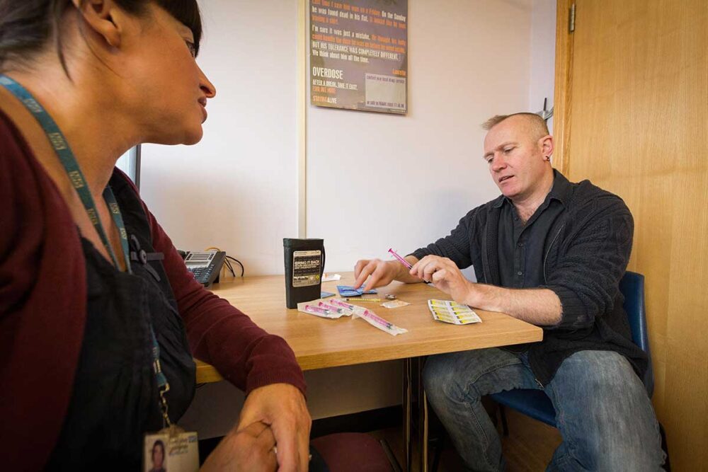 Man with female clinician at a drug treatment centre