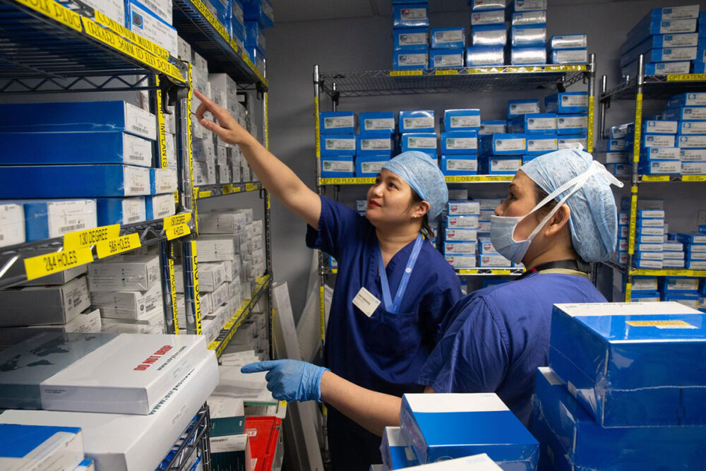 Two clinical staff finding stock in hospital storeroom