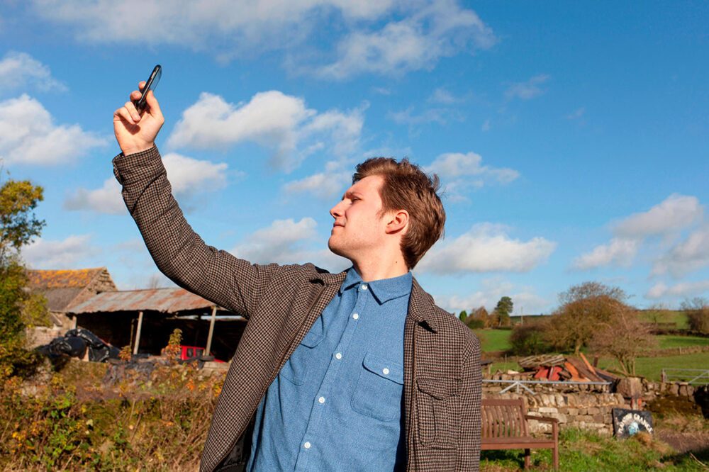 Man on a farm trying to get mobile phone reception