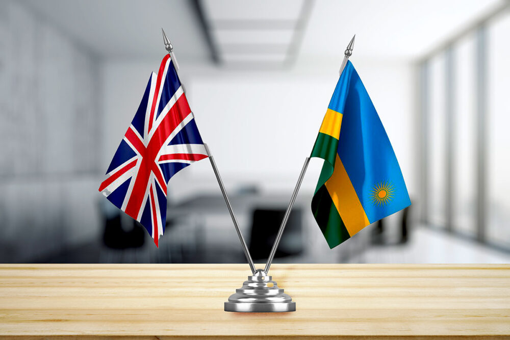 The UK and Rwandan flags in a stand on a desk