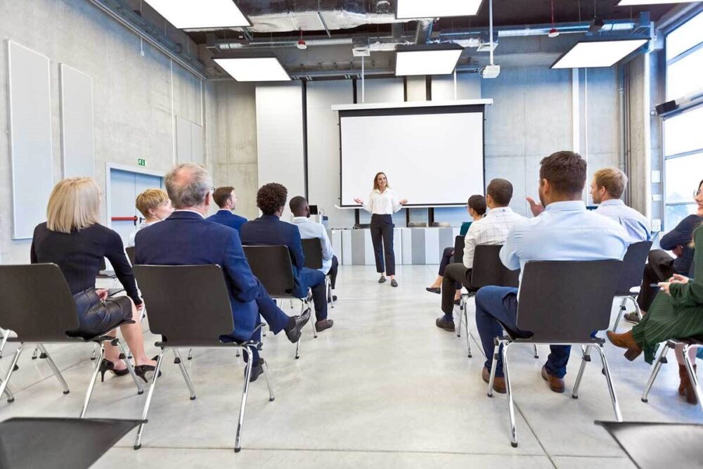 People sitting in a hall, on a training course.